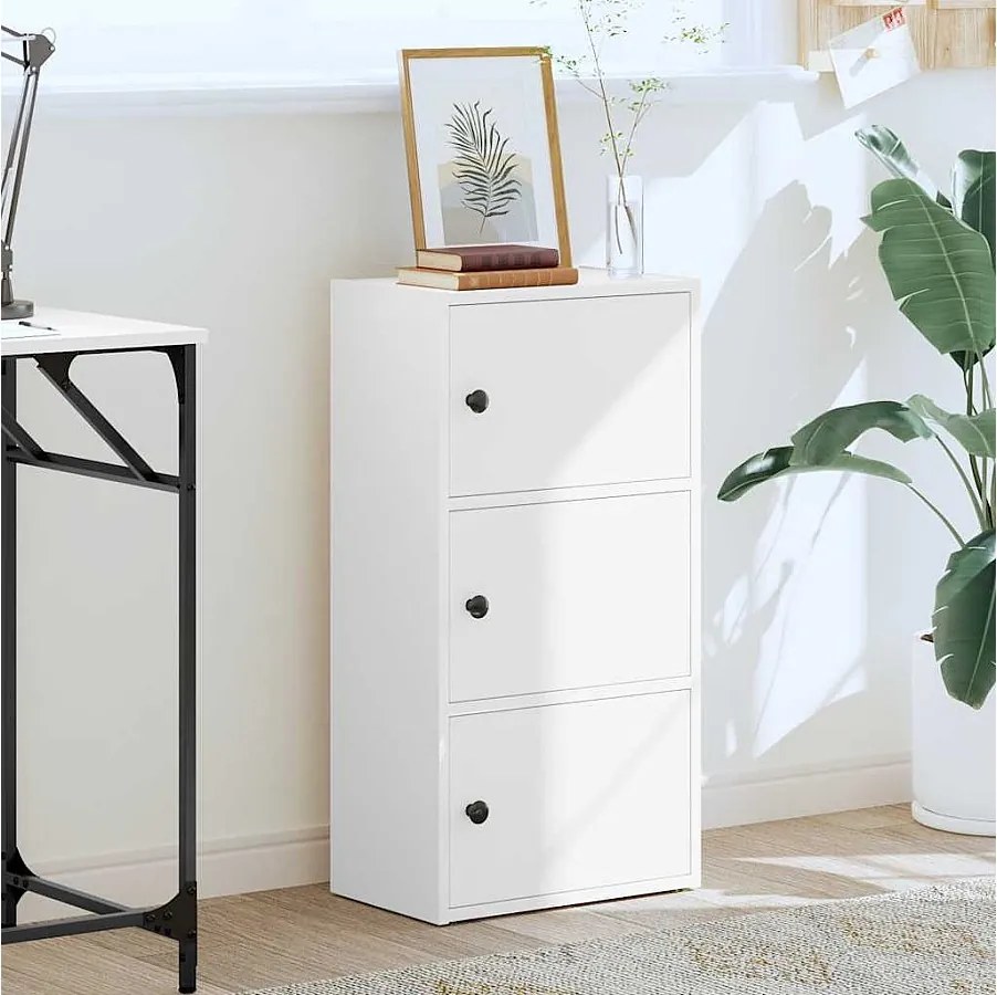 Biała biblioteczka narożna 40x24x77 cm z drewna inżynieryjnego z odwracalnymi drzwiami i zamkniętą przestrzenią do przechowywania