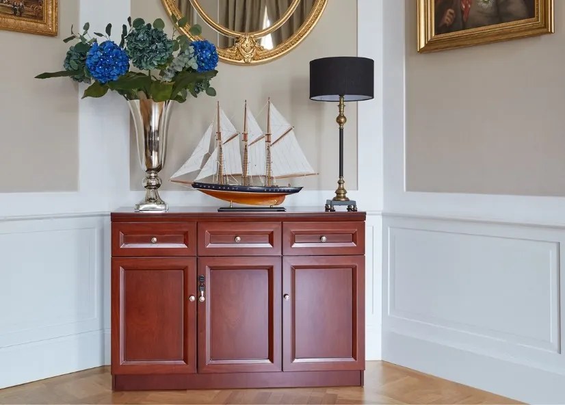 Elegancka klasyczna komoda do biura Elegance. Komoda ma 3 drzwi i 3 szuflady. Podwójne drzwi są zamykane na kluczyk, fronty wykończone płyciną, komoda jest fornirowana drewnem.