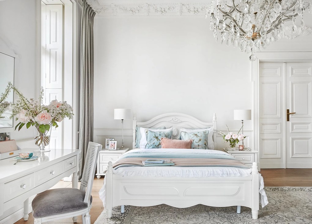 Stylowe, białe łóżko sypialniane Caroline, dostępne wymiary 140x200, 160x200 i 180x200. Rama frezowana, zagłówek ze sztukaterią, w rogach tralki.