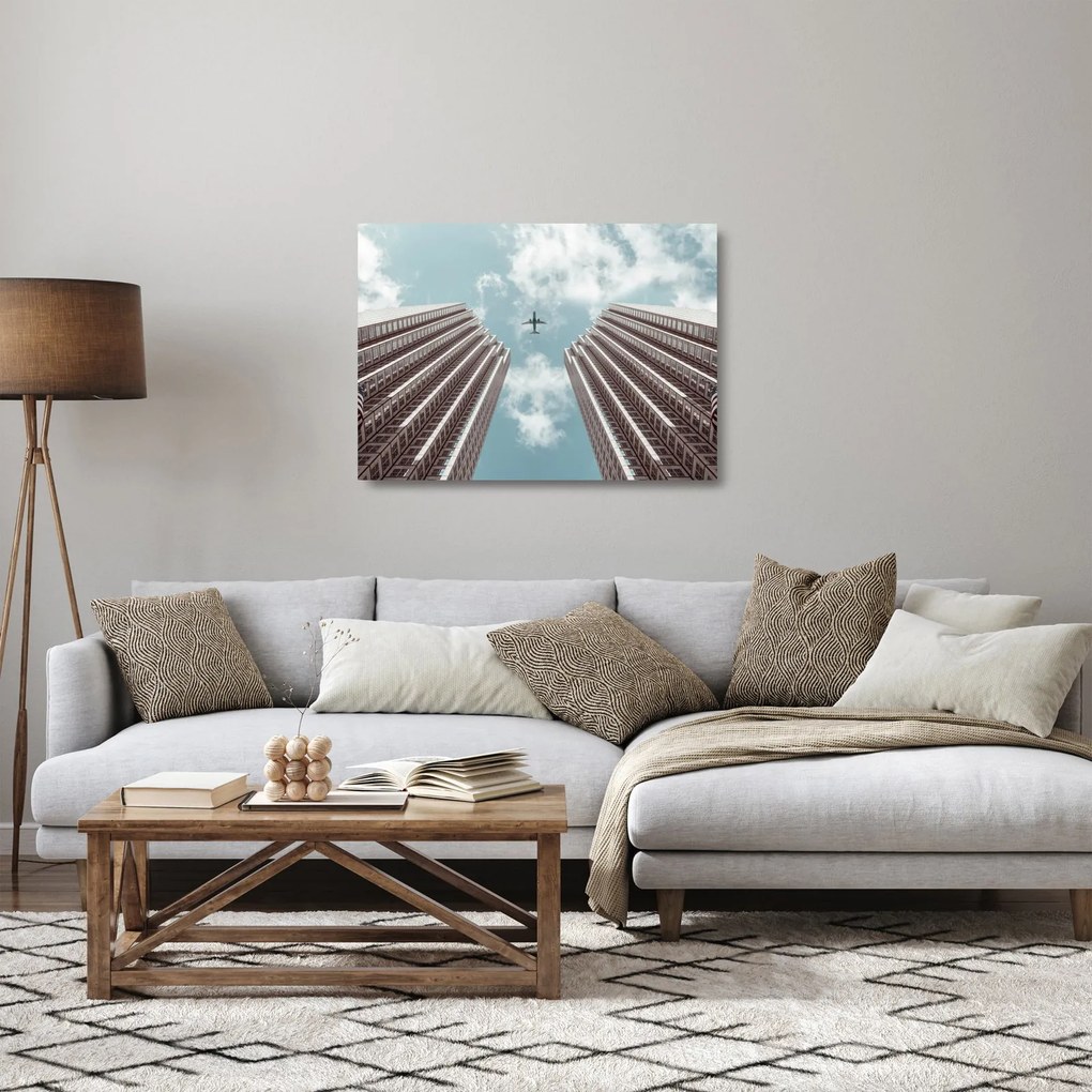 Obraz na szkle samolotu między budynkami (70x50 cm)