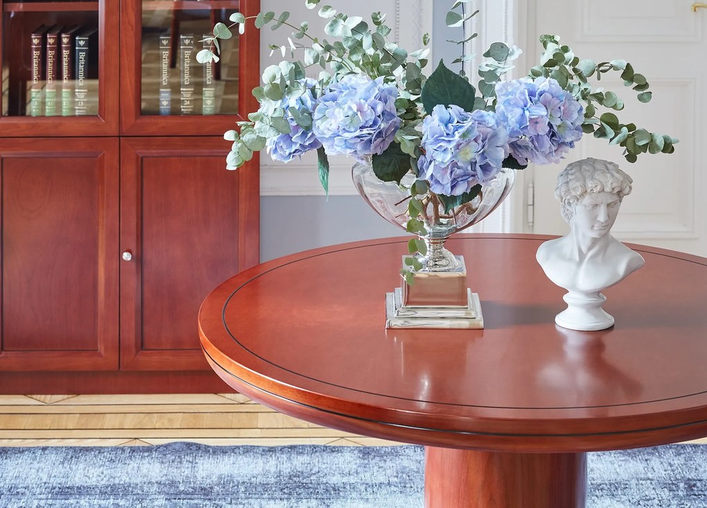 Elegancki stół biurowy o okrągłym blacie Conference. Dwa rozmiary średnicy do wyboru: 90 cm i 120 cm. Stół fornirowany drewnem w odcieniu koniaku, okrągła podstawa, stylowe wykończenie.