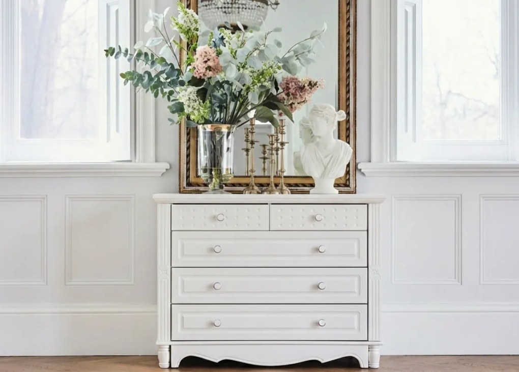 Stylowa biała komoda z 5 szufladami Lily, do salonu lub sypialni. Dekoracyjne fronty i białe gałki z ceramiki. Angielskie białe meble Victoria.