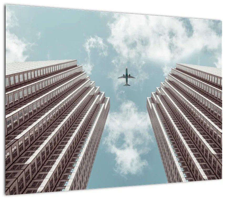 Obraz na szkle samolotu między budynkami (70x50 cm)