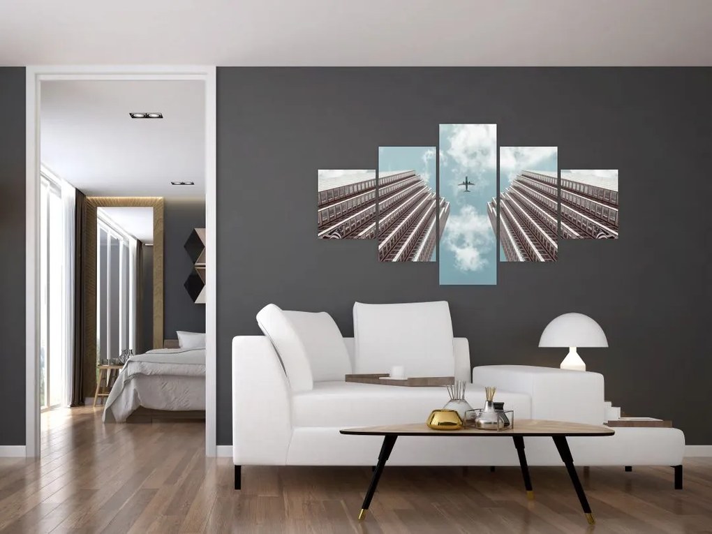Obraz samolotu między budynkami (125x70 cm)