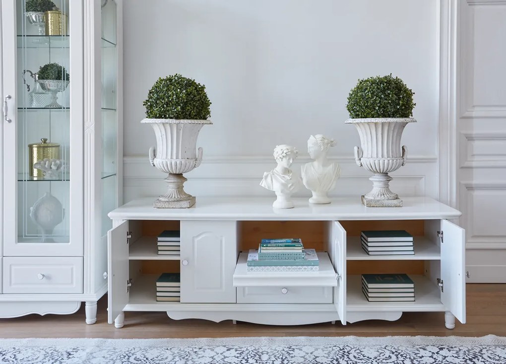 Stylowa biała szafka pod telewizor Sybilla 180x58x62 cm. Komoda rtv z podwójnymi drzwiami, półką i szufladą, delikatne zdobienia. Angielski styl, białe meble.