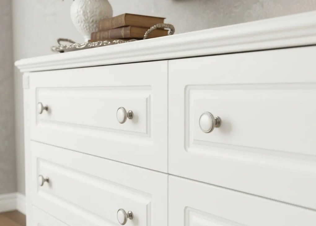 Biała komoda z szufladami Nelia. 6 pojemnych szuflad w dwóch rzędach, białe gałki, frezowania. Komoda do salonu, komoda do sypialni.