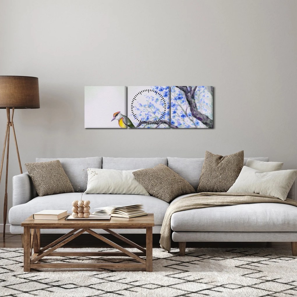 Obraz - ptak na drzewie z niebieskimi kwiatami (z zegarem) (90x30 cm)