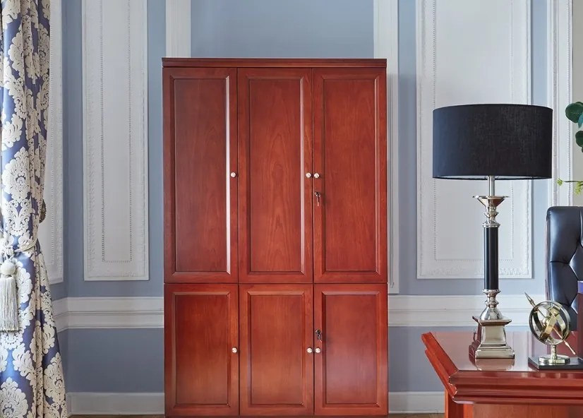 Klasyczna szafa biurowa w kolorze koniaku, fornirowana. Szafa ma pełne drzwi, fronty wykończone płyciną, regulowane półki, drzwi zamykane na kluczyk. W szafie zamiast półek można zamontować wieszak.