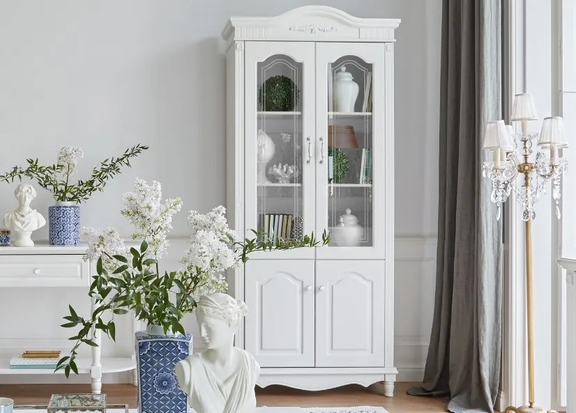 Biały regał do salonu Beatrice, wymiary 98x43x223 cm. Przeszklone fronty, wewnątrz półki. Białe angielskie meble Victoria.