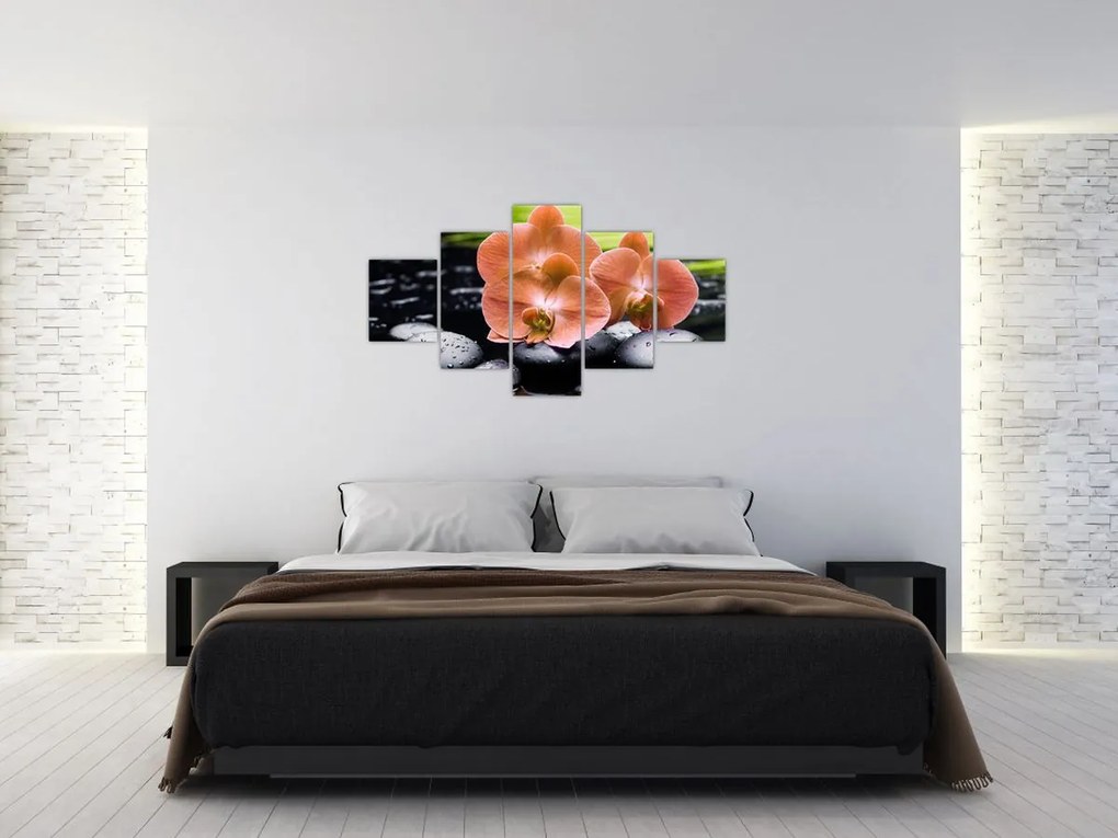 Obraz - Pomarańczowa orchidea z liśćmi palmy (125x70 cm)