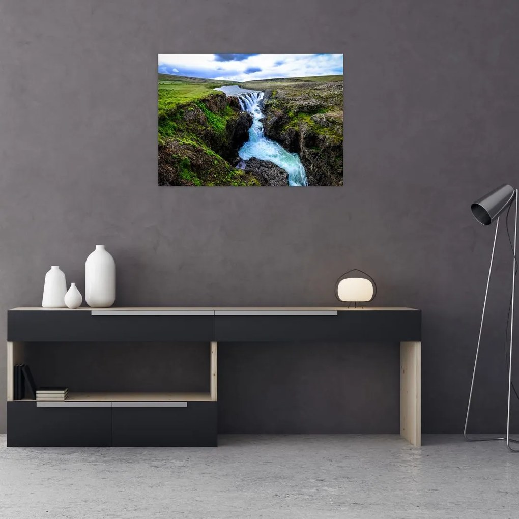 Obraz na szkle wodospadu między skałami (70x50 cm)