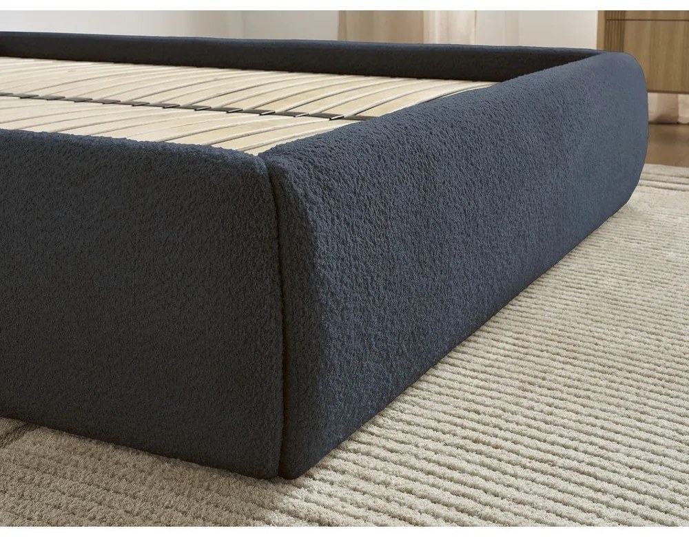 Ciemnoniebieskie tapicerowane łóżko dwuosobowe bez zagłówka ze schowkiem i stelażem 180x200 cm Inera – Bobochic Paris