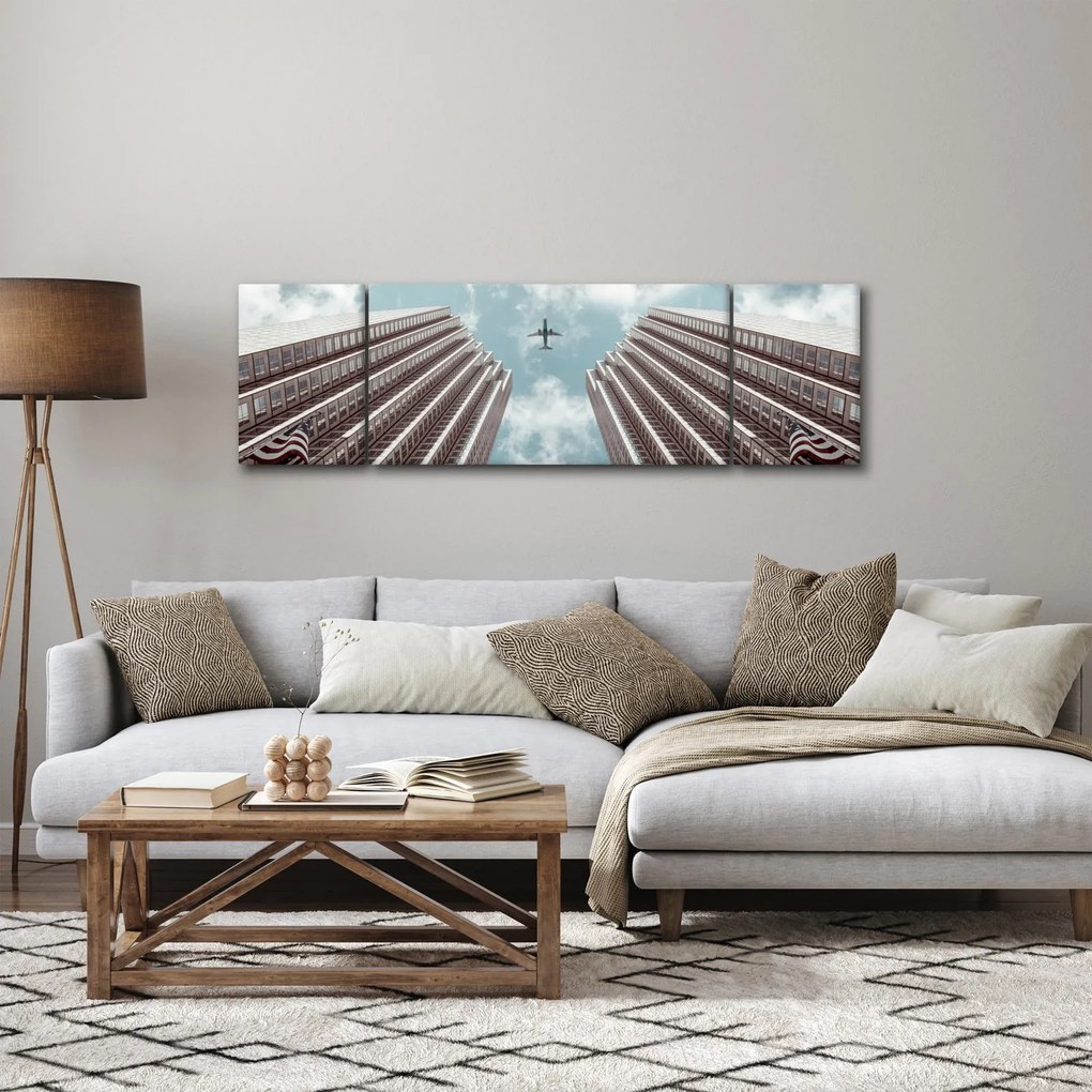 Obraz samolotu między budynkami (170x50 cm)