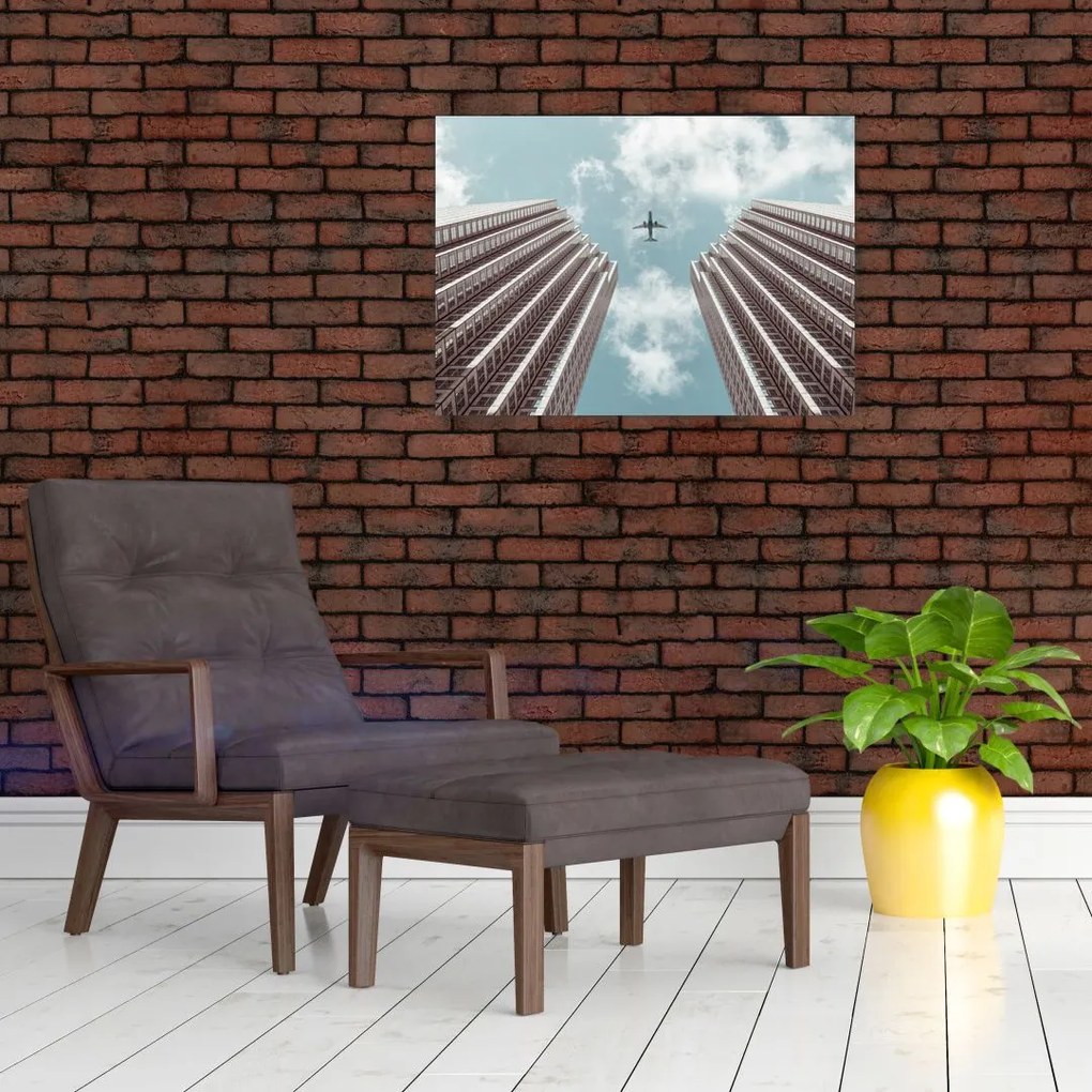 Obraz na szkle samolotu między budynkami (70x50 cm)