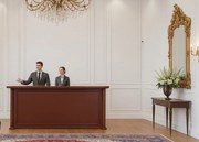 Elegancka lada recepcyjna Simposio fornirowana do recepcji, wymiary lady 220x50x110 cm. Lada recepcyjna w kolorze koniaku, ma klasyczne wykończenie. Sprawdzi się w stylowym biurze, recepcji lub hallu.