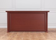 Elegancka lada recepcyjna Simposio fornirowana do recepcji, wymiary lady 220x50x110 cm. Lada recepcyjna w kolorze koniaku, ma klasyczne wykończenie. Sprawdzi się w stylowym biurze, recepcji lub hallu.
