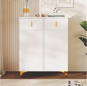 Biała szafka na buty z szufladami, teksturowanymi drzwiami, regulowanymi półkami oraz złotymi uchwytami i nóżkami