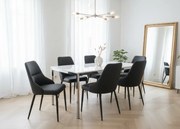 Eleganckie czarne krzesło Monolit tapicerowane ekoskórą PU, wygodne, nowoczesne i idealne do jadalni lub biura. Smukłe metalowe nogi dodają mu lekkości i stylu.