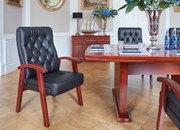 Eleganckie krzesło gabinetowe Consul tapicerowane skórą naturalną w kolorze brązowym, czarnym lub kremowym. Krzesło ma drewnianą ramę i podłokietniki, jest wygodne i solidnie wykonane.