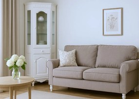 Witryna do salonu narożna biała Aria, wymiary 65x65x200 cm. Górna część przeszklona, dolna zamknięta. Witryna ma szafkę i szufladę. Angielski styl.