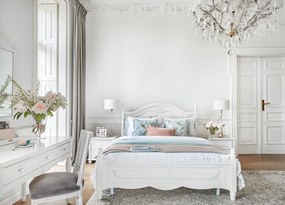 Stylowe, białe łóżko sypialniane Caroline, dostępne wymiary 140x200, 160x200 i 180x200. Rama frezowana, zagłówek ze sztukaterią, w rogach tralki.