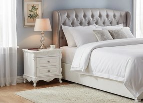 Stylowa szafka nocna Amenite, o wymiarach 60x55 cm, w kolorze ecru. 2 szufladki, ozdobne fronty, cokół, gałki. Styl francuski, kolekcja La Perle.