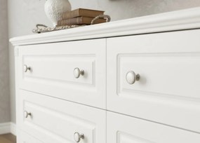 Biała komoda z szufladami Nelia. 6 pojemnych szuflad w dwóch rzędach, białe gałki, frezowania. Komoda do salonu, komoda do sypialni.