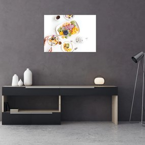 Obraz na szkle talerzy z owocami na stole (70x50 cm)