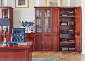 Elegancka szafa do biura Diamante. Szafa ma pełne drzwi, zamki na kluczyk, fronty wykończone płyciną, półki o regulowanej wysokości. Jest elegancko fornirowana na kolor koniaku, ma piękny cokół i gzyms.