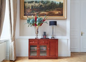 Elegancka klasyczna komoda do gabinetu Elegance. Komoda jest 3-drzwiowa, ma 2 drzwi przeszklonych, 2 szuflady. Komoda jest fornirowana, fronty wykończone płyciną. Funkcjonalna komoda biurowa.