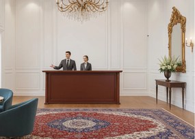 Elegancka lada recepcyjna Simposio fornirowana do recepcji, wymiary lady 220x50x110 cm. Lada recepcyjna w kolorze koniaku, ma klasyczne wykończenie. Sprawdzi się w stylowym biurze, recepcji lub hallu.