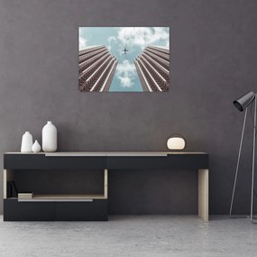 Obraz na szkle samolotu między budynkami (70x50 cm)