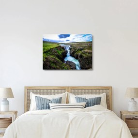 Obraz na szkle wodospadu między skałami (70x50 cm)