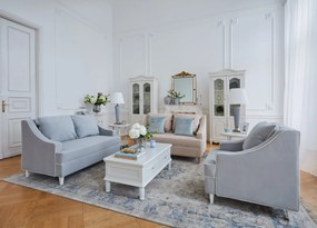 Kanapa sofa dwuosobowa do salonu. Sofa na drewnianych nóżkach, tapicerowana tkaniną welwetową. Sofa ma eleganckie podłokietniki, krawędzie obszyte kedrą, niebieska lub beżowa.