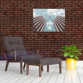 Obraz na szkle samolotu między budynkami (70x50 cm)